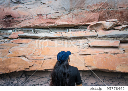 Asian woman travel and discover the prehistoric art painting of Pha Taem National Park in Ubon Ratchathani province of Thailand. 95778462