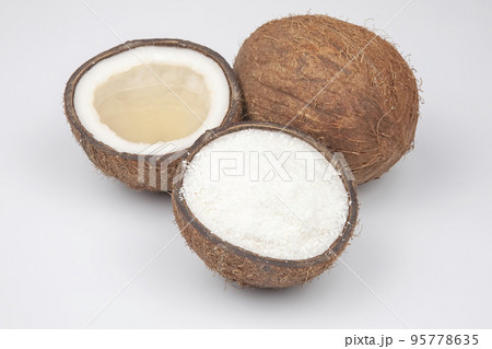 coconut halves with coconut, milk and pulp on a white background coconut halves with coconut, milk and pulp on a white background 95778635