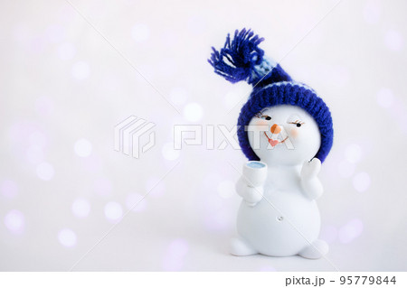 Christmas background. Happy snowman standing in winter christmas landscape with a glass. Merry christmas and happy new year greeting card. Funny snowman in hat. Banner. Copy space 95779844