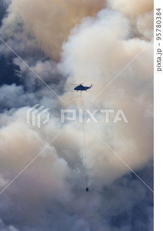 Wildfire Service Helicopter flying over BC Forest Fire and Smoke on the mountain near Hope Wildfire Service Helicopter flying over BC Forest Fire and Smoke on the mountain near Hope 95780384