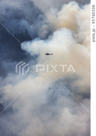 Wildfire Service Helicopter flying over BC Forest Fire and Smoke on the mountain near Hope Wildfire Service Helicopter flying over BC Forest Fire and Smoke on the mountain near Hope 95780506