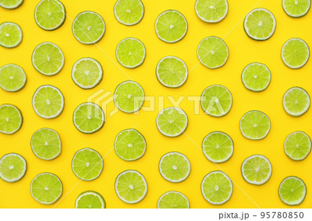 Slices of fresh juicy limes on yellow background, flat lay Slices of fresh juicy limes on yellow background, flat lay 95780850