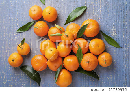 Fresh ripe tangerines on grey wooden table, flat lay 95780936
