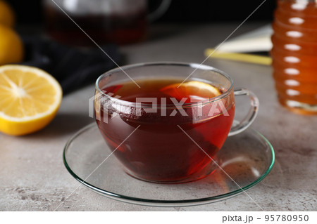Fresh tea with honey and lemon on light grey table, closeup 95780950