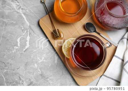 Flat lay composition of tea with honey on light grey marble table. Space for text Flat lay composition of tea with honey on light grey marble table. Space for text 95780951