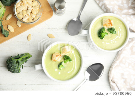 Delicious broccoli cream soup with croutons served on white wooden table, flat lay Delicious broccoli cream soup with croutons served on white wooden table, flat lay 95780960