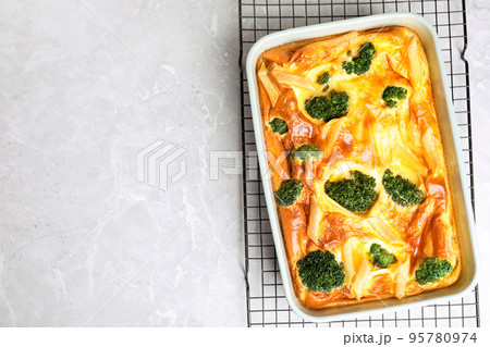 Tasty broccoli casserole in baking dish on cooling rack, top view. Space for text Tasty broccoli casserole in baking dish on cooling rack, top view. Space for text 95780974