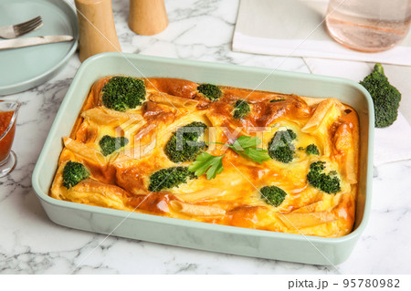 Tasty broccoli casserole in baking dish on white marble table Tasty broccoli casserole in baking dish on white marble table 95780982