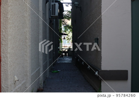 建物の間の路地と先に見える樹とビルの街並みの風景 建物の間の路地と先に見える樹とビルの街並みの風景 95784260