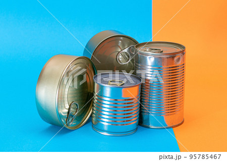 A Group of Stacked Tin Cans with Blank Edges on Split Blue and Orange Background A Group of Stacked Tin Cans with Blank Edges on Split Blue and Orange Background 95785467