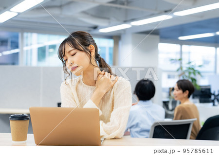 職場で肩こりを感じる女性 95785611