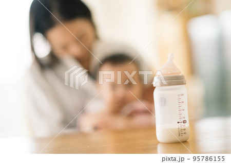 哺乳瓶と椅子に座るママと赤ちゃん 95786155