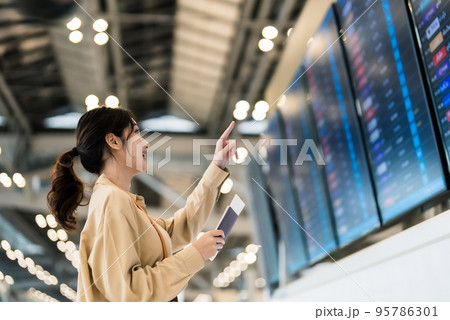 Young asian woman with passport and boarding pass Young asian woman with passport and boarding pass 95786301