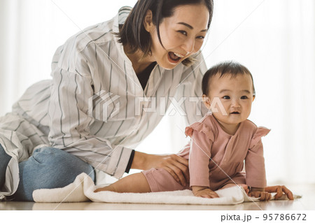 立ち上がろうとする赤ちゃんと、あやすママ 立ち上がろうとする赤ちゃんと、あやすママ 95786672