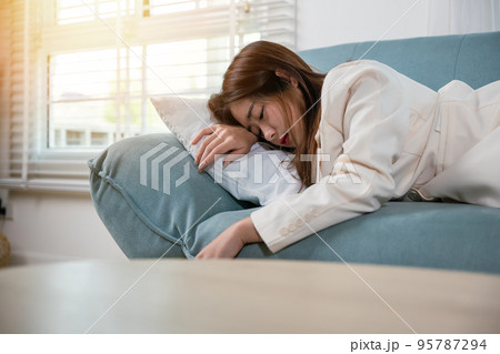 Tired woman sleeping closed eyes on sofa in living room at home 95787294