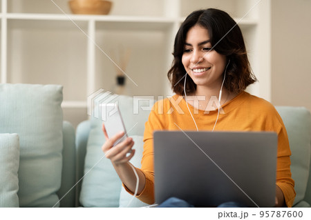 Digital Leisure. Smiling Middle Eastern Female Resting With Laptop And Smartphone Digital Leisure. Smiling Middle Eastern Female Resting With Laptop And Smartphone 95787600