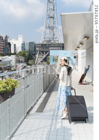 スーツケースを引いて名古屋観光をする若い女性 振り返り スーツケースを引いて名古屋観光をする若い女性 振り返り 95787852