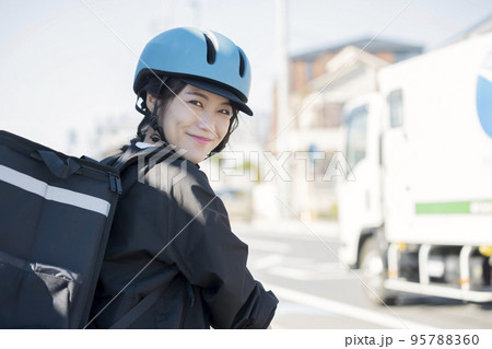 フードデリバリーイメージ　自転車でデリバリーする若い女性 シェアデリ 95788360