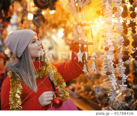 Positive smiling woman at fair near counter with Christmas gifts 95788416