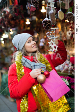 Happy girl chooses Christmas toys on the street market Happy girl chooses Christmas toys on the street market 95788462