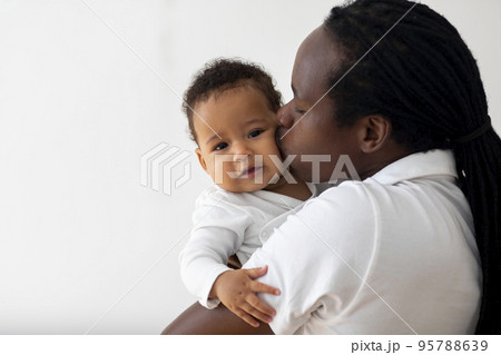 Loving Young Black Dad Holding And Kissing His Adorable Baby Son, Closeup Loving Young Black Dad Holding And Kissing His Adorable Baby Son, Closeup 95788639
