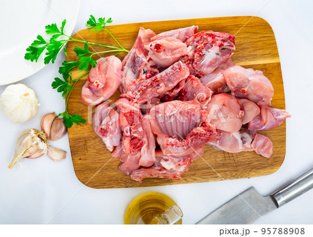 Chopped rabbit with onion, garlic and spices on kitchen board with knife Chopped rabbit with onion, garlic and spices on kitchen board with knife 95788908