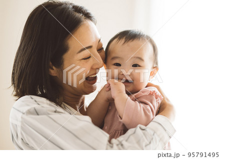 赤ちゃんを抱っこする笑顔のママ 95791495