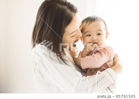 赤ちゃんを抱っこする笑顔のママ 95791505