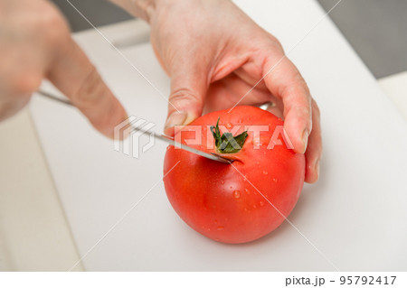 【トマトのヘタを三徳包丁で切る】 95792417
