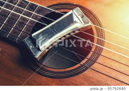 vintage harmonica on acoustic guitar vintage harmonica on acoustic guitar 95792680