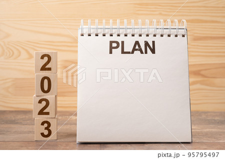 Mockup 2023 notepad with PLAN text. Text 2023 on wooden cubes. space for your text on notepad, New Year. startup concept. wooden background. Concept of new year planning. Mockup 2023 notepad with PLAN text. Text 2023 on wooden cubes. space for your text on notepad, New Year. startup concept. wooden background. Concept of new year planning. 95795497