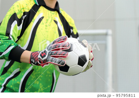 サッカーボールをキャッチするゴールキーパーの男性 95795811