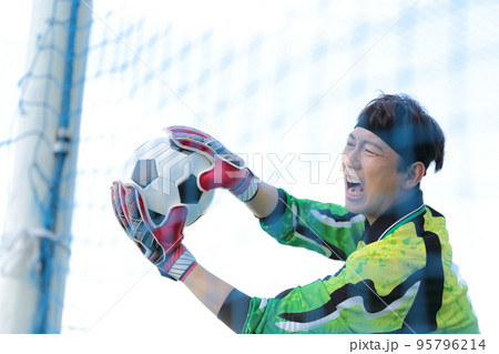 サッカーボールをキャッチするゴールキーパーの男性 サッカーボールをキャッチするゴールキーパーの男性 95796214