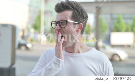 Portrait of Sleepy Young Man Yawning Outdoor 95797426