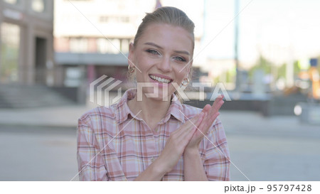 Young Woman Clapping in Appreciation Outdoor Young Woman Clapping in Appreciation Outdoor 95797428
