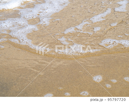 穏やかな海の波打ち際と砂浜。 95797720