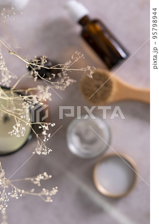 Skin care product for oil face massage and flowers on white table. Selective focus. Eco friendly organic reusable self care accessories. Skin care product for oil face massage and flowers on white table. Selective focus. Eco friendly organic reusable self care accessories. 95798944