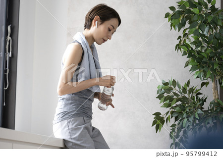トレーニングの後休憩する女性　水分補給　ワークアウト 95799412