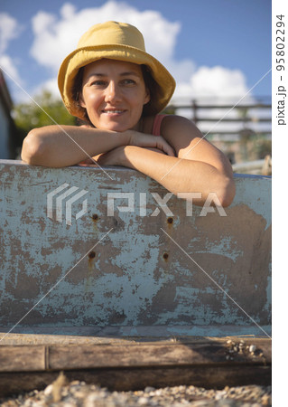 Smiling tanned female in yellow hat relaxing posing on sunny beach enjoy summer travel vacation Smiling tanned female in yellow hat relaxing posing on sunny beach enjoy summer travel vacation 95802294