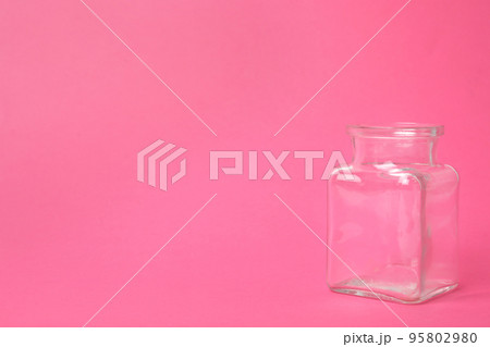 Open empty glass jar on pink background, space for text 95802980