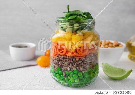 Healthy salad in glass jar on light table 95803000