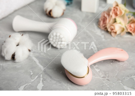 Modern face cleansing brush on light grey marble table. Cosmetic accessory Modern face cleansing brush on light grey marble table. Cosmetic accessory 95803315