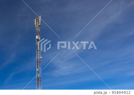 Telecommunication tower for mobile phone with antennas over a blue sky. Distribution function of contract mobile phones Telecommunication tower for mobile phone with antennas over a blue sky. Distribution function of contract mobile phones 95804912