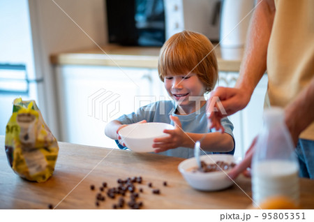 Young father making breakfast for his little son Young father making breakfast for his little son 95805351