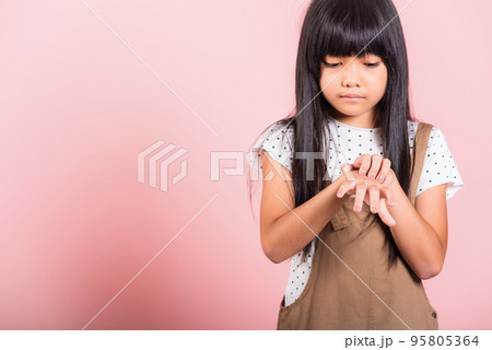 Asian little kid 10 years old scratching itch back hand from mosquito bite Asian little kid 10 years old scratching itch back hand from mosquito bite 95805364