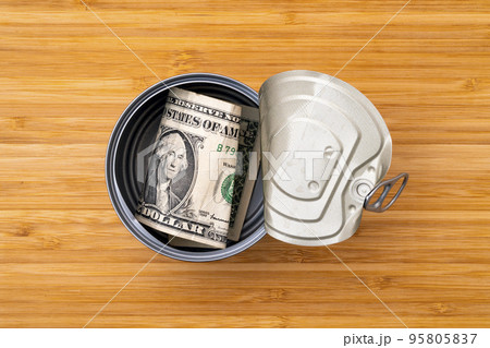 Open tin can with money of the USA 95805837