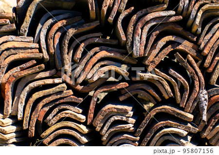 A stack of tiles, a clay roof, background and texture. Front view. 95807156