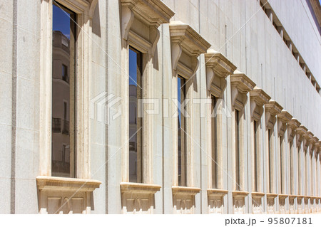 Classic old European architecture. Detail of an old beige building with many windows with beautiful frames, stucco. Spanish architecture in sunny day. Construction, preservation of buildings, houses. Classic old European architecture. Detail of an old beige building with many windows with beautiful frames, stucco. Spanish architecture in sunny day. Construction, preservation of buildings, houses. 95807181