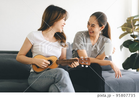 Two young adult woman living together with relationship relax lifestyle at home 95807735