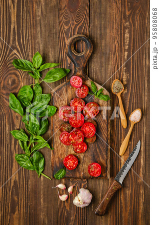 Overhead view of slices of tomato sprinkled with salt and pepper 95808068